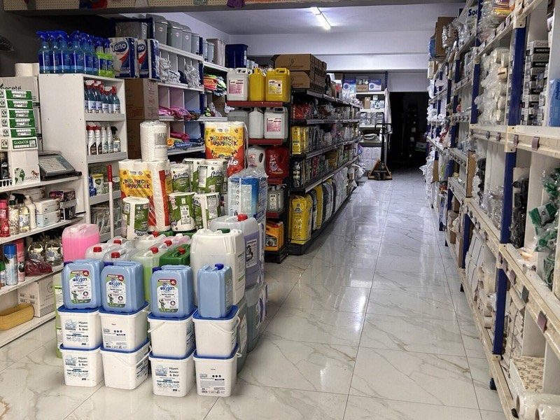 Mağaza koridorunda endüstriyel temizlik kimyasalları, bidonlar ve hijyen kovaları